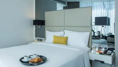 a large white bed with a bowl of food on it at Centro Westside by Rotana in Istanbul