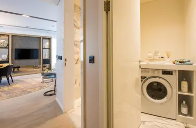 a washing machine in a room with a living room at WestSide Residences by Rotana in Istanbul
