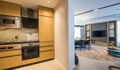 a kitchen with wooden cabinets and a dining room at WestSide Residences by Rotana in Istanbul