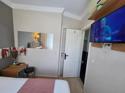 a hotel room with a bed and a flat screen tv at TAKSİM LİFE HOUSE in Istanbul