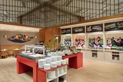 a restaurant with a counter with white plates on it at Hampton By Hilton Bursa in Bursa