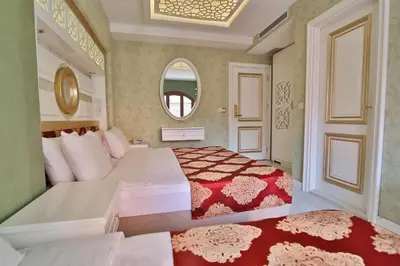 a hotel room with two beds and a mirror at Hotel Queens Land in Istanbul