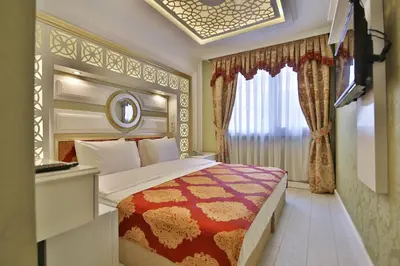a bedroom with a large bed and a window at Hotel Queens Land in Istanbul