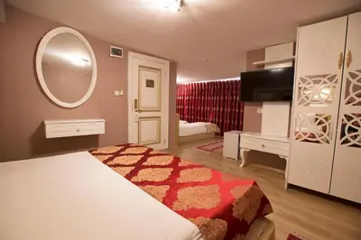 a bedroom with a bed and a mirror and a tv at Hotel Queens Land in Istanbul