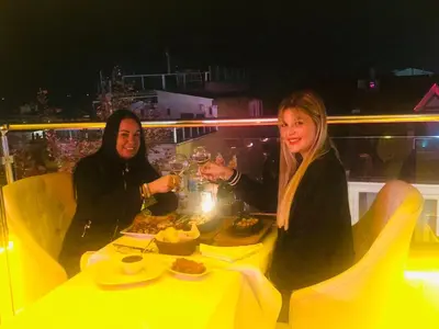 two women sitting at a table with wine glasses at Charm Hotel in Istanbul