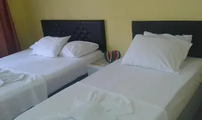 two beds in a room with white sheets and pillows at Bereket traveler Hotel in Istanbul