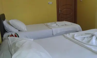 two beds in a hotel room with white sheets and towels at Bereket traveler Hotel in Istanbul
