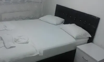 a white bed with white pillows and a black headboard at Bereket traveler Hotel in Istanbul
