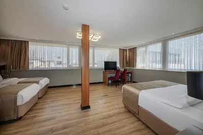 a hotel room with two beds and a desk at Aristocrat Hotel in Istanbul