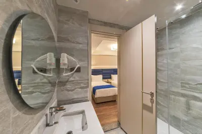a bathroom with a sink and a mirror and a bedroom at Golden Royal Hotel & SPA in Istanbul