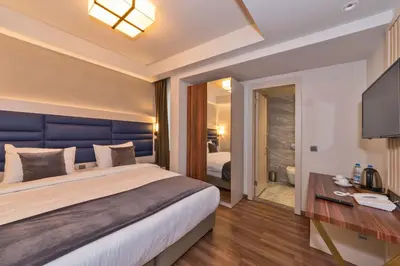 a bedroom with a large bed and a television at Golden Royal Hotel & SPA in Istanbul