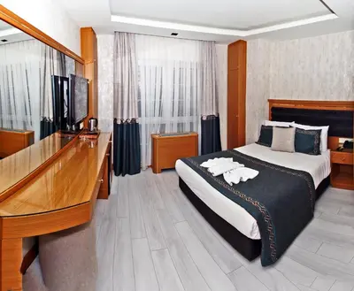 a bedroom with a bed and a desk and a television at Grand Emir Hotel Old City in Istanbul