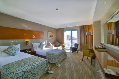 a hotel room with two beds and a desk at Innova Sultanahmet Istanbul in Istanbul