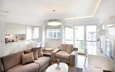 a living room with a couch and chairs and a kitchen at Nuru Ziya Residences in Istanbul