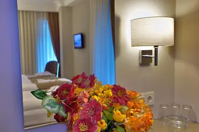 a vase of flowers on a table in a hotel room at Laleli Emin Old City Hotel in Istanbul