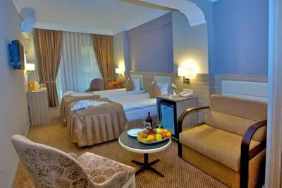 a hotel room with two beds and a couch and a table at Laleli Emin Old City Hotel in Istanbul