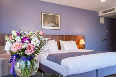 a bedroom with a bed and a vase of flowers on a table at La Wisteria Boutique Hotel Istanbul in Istanbul