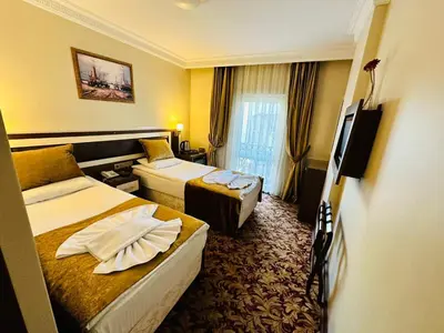 a hotel room with two beds and a television at Grand Anatolia Hotel in Istanbul