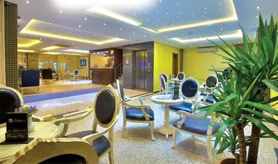 a lobby with tables and chairs in a building at Grand Anatolia Hotel in Istanbul