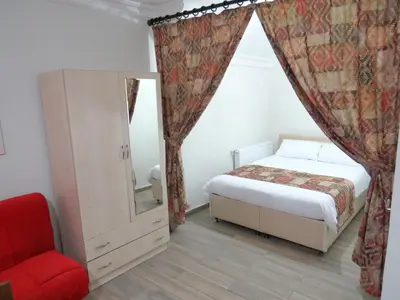 a bedroom with a bed and a chair and a mirror at Istanberry - Paradise Apartments in Istanbul
