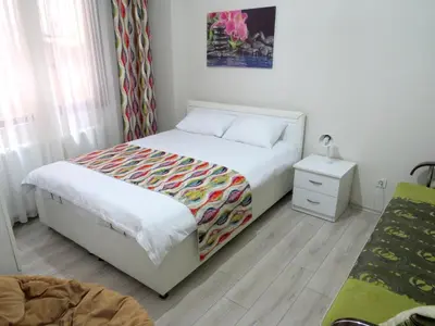 a small bedroom with a bed and a night stand at Istanberry - Paradise Apartments in Istanbul