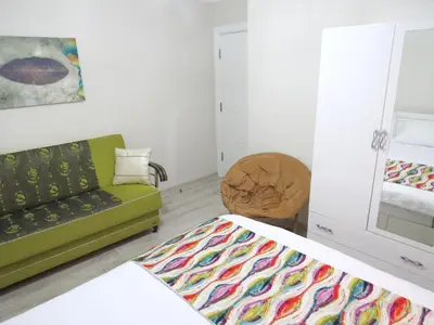 a living room with a green couch and a chair at Istanberry - Paradise Apartments in Istanbul