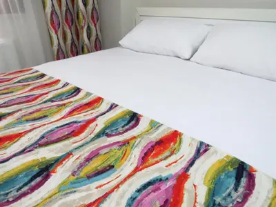 a bed with a multicolored blanket on it at Istanberry - Paradise Apartments in Istanbul