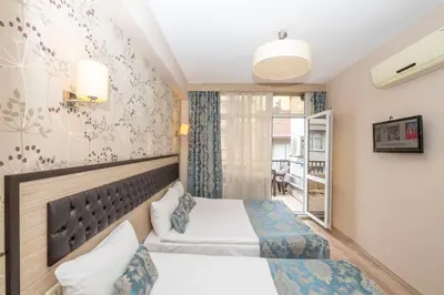a hotel room with two beds and a window at Tugra Hotel in Istanbul