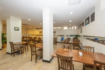 an empty restaurant with wooden tables and chairs at Tugra Hotel in Istanbul