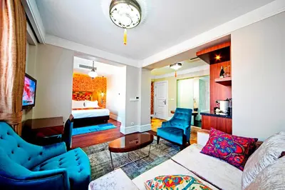 a living room with a couch and chairs and a bed at Azade Suites in Istanbul
