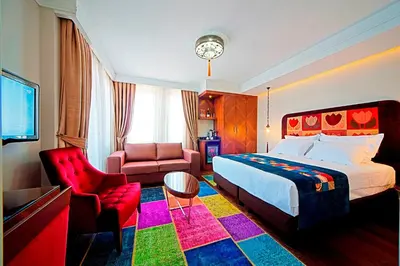a hotel room with a bed and a chair at Azade Suites in Istanbul