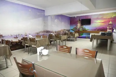 a restaurant with tables and chairs and a large painting on the wall at Ramparts Hotel in Istanbul