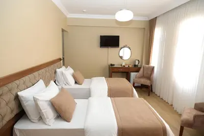 a hotel room with two beds and a desk at Ramparts Hotel in Istanbul