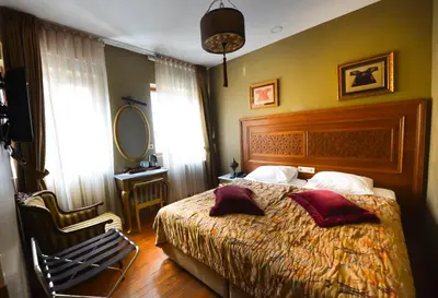 a bedroom with a bed and a chair and a mirror at Merial Hotel Sultanahmet in Istanbul