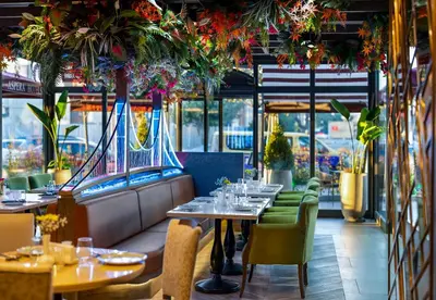 a restaurant with tables and chairs and plants at Aspera Hotel Altunizade in Istanbul