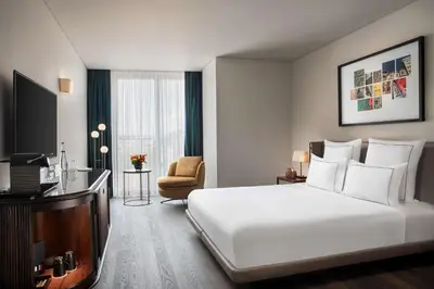 a hotel room with a large white bed and a chair at Glens Palas Istanbul Nisantasi in Istanbul