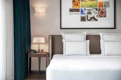 a bedroom with a bed and a table with a lamp at Glens Palas Istanbul Nisantasi in Istanbul