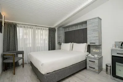 a bedroom with a large white bed and a television at Faros Hotel Taksim-Special Category in Istanbul