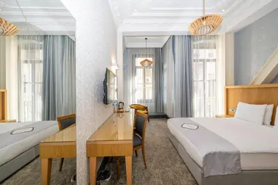 a hotel room with two beds and a desk at Premist Hotels Taksim in Istanbul