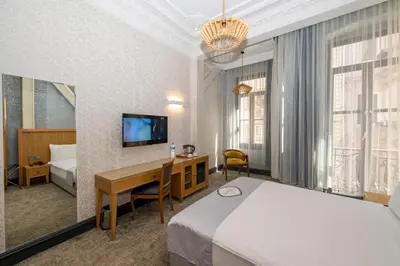 a hotel room with a bed and a desk and a television at Premist Hotels Taksim in Istanbul