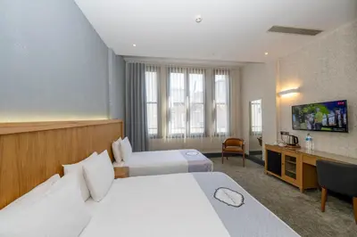 a hotel room with two beds and a desk at Premist Hotels Taksim in Istanbul