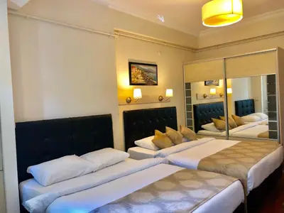 a hotel room with two beds and a mirror at Taksim House Suites in Istanbul