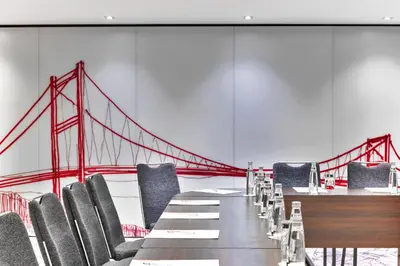a long table and chairs in a room with a bridge at Le Meridien Istanbul Etiler in Istanbul