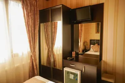 a bedroom with a mirror and a dresser with a bed at Eskibağ Butik Hotel in Buyukada