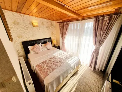 a bedroom with a large bed and a window at Eskibağ Butik Hotel in Buyukada