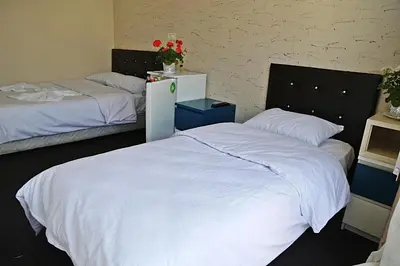 a bedroom with two beds with white sheets and red flowers at holiday family apart in Istanbul