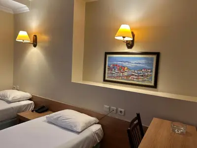 a hotel room with two beds and a table and lights at Haydarpasa Hotel in Istanbul