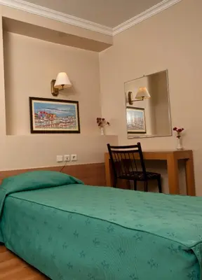 a bedroom with a bed and a desk and a mirror at Haydarpasa Hotel in Istanbul