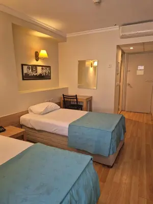 a hotel room with two beds and a table at Haydarpasa Hotel in Istanbul