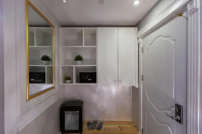 a hallway with white cabinets and a mirror at Sirkeci Ersu Hotel & SPA in Istanbul
